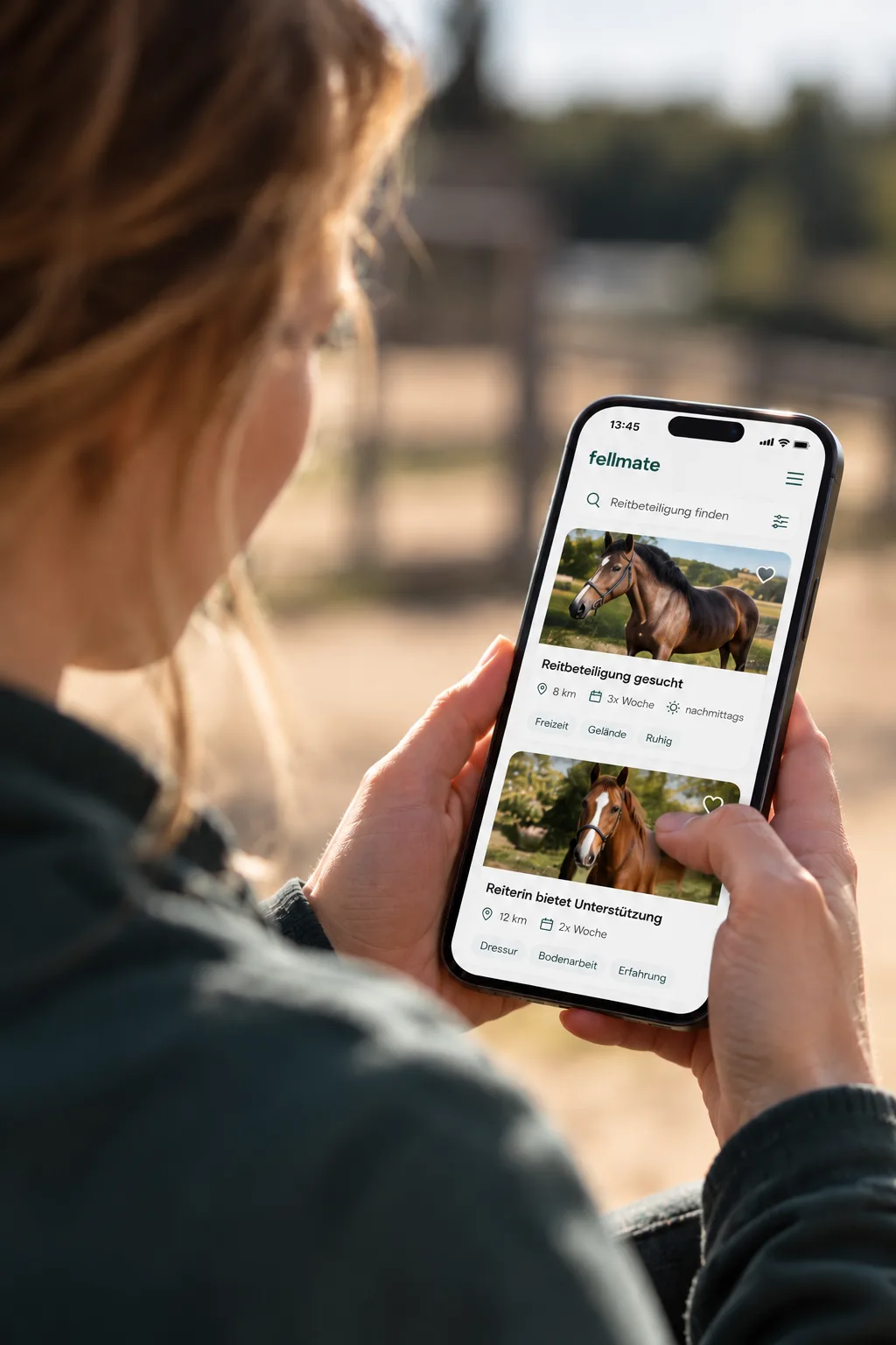 Reiterin sieht sich auf dem Smartphone Reitbeteiligungen in der fellmate-Suche an